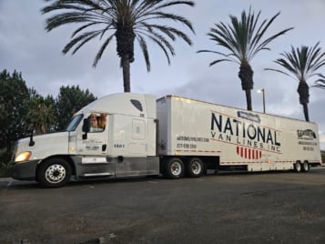 National Van Lines semi-trailer parked beside palm trees on a long-distance move